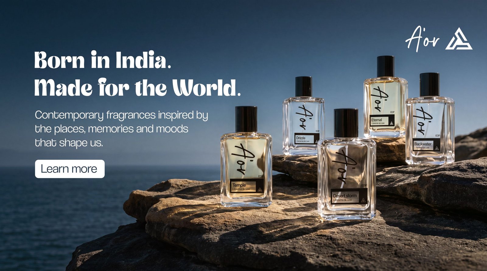 A'OR perfume bottles on coastal rocks above the sea