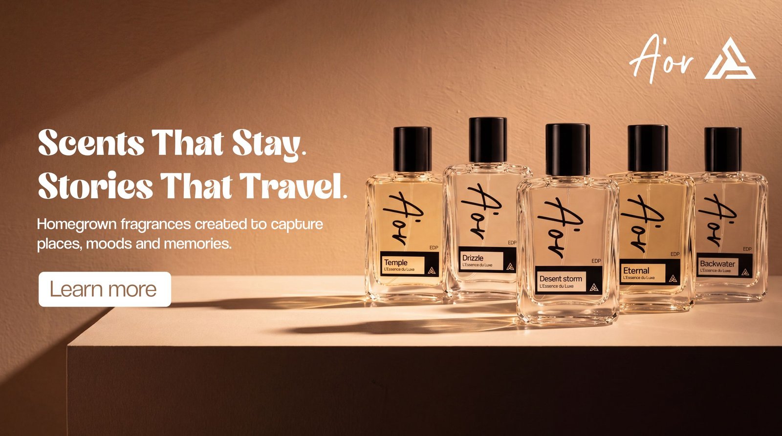 A row of five A'OR perfume bottles in warm evening light